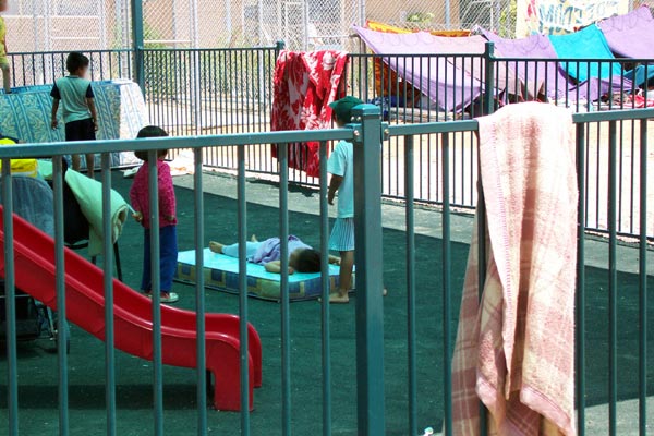 Children in playground at Woomera with hunger strike in background, January 2002.